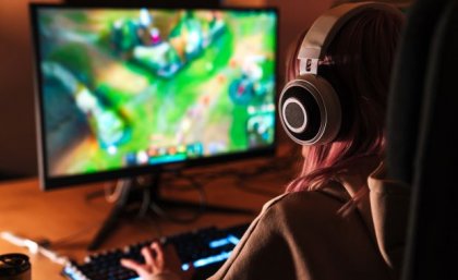 Young woman playing games on a personal computer. Image, Adobe.